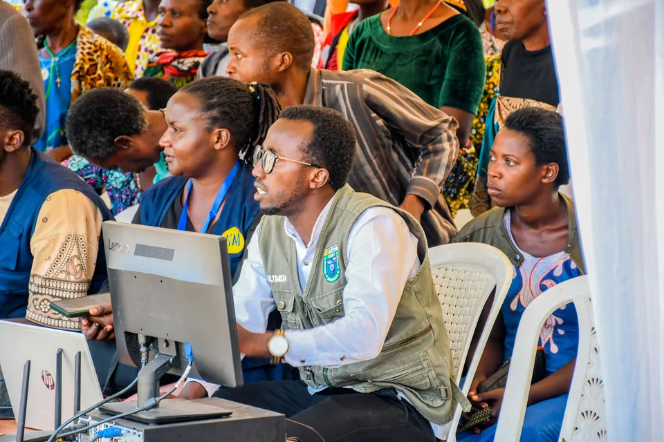 People engaging with technology at a community event in Rwanda